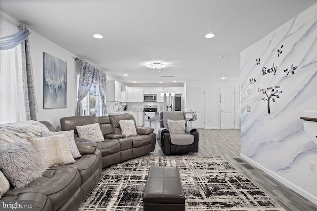 living area with recessed lighting, baseboards, and light wood-type flooring