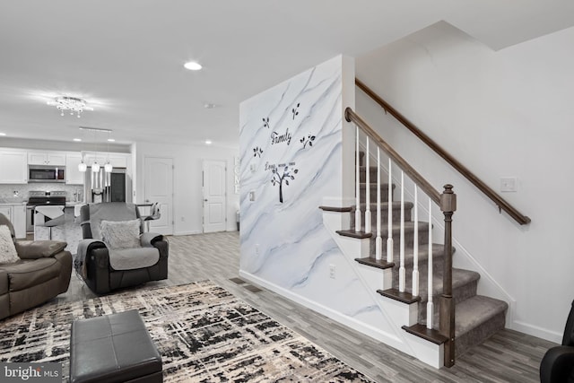 stairs featuring recessed lighting, baseboards, and wood finished floors