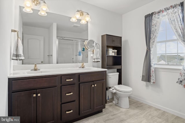 bathroom with baseboards, a sink, a stall shower, and toilet