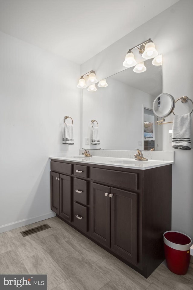 bathroom featuring a sink, double vanity, and visible vents