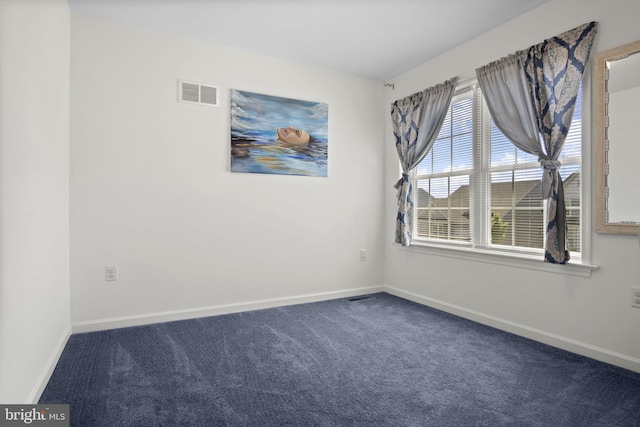 carpeted spare room featuring baseboards and visible vents
