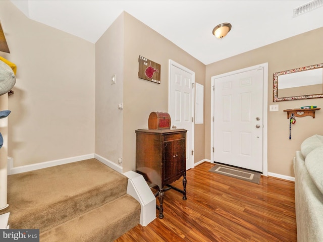 entryway featuring wood finished floors, visible vents, and baseboards