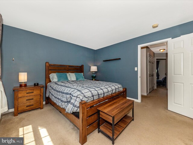 bedroom featuring light colored carpet and baseboards