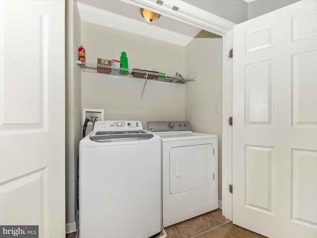 washroom with washer and dryer, light tile patterned flooring, and laundry area