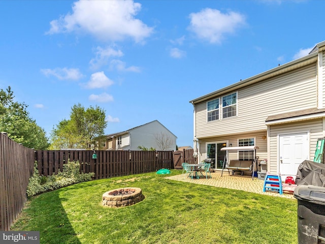 back of house featuring a patio, a fenced backyard, a gate, a lawn, and a fire pit