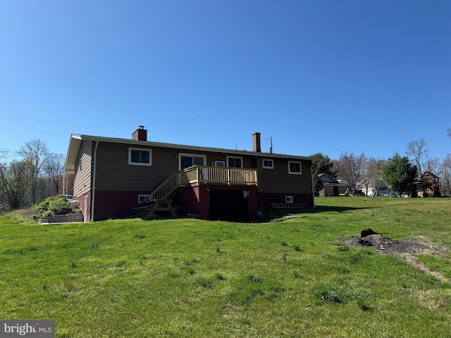 back of property featuring a lawn, a chimney, stairs, and a wooden deck