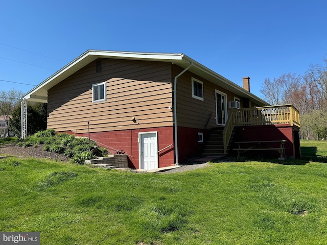 view of home's exterior with a chimney, a wall unit AC, a yard, stairway, and a wooden deck