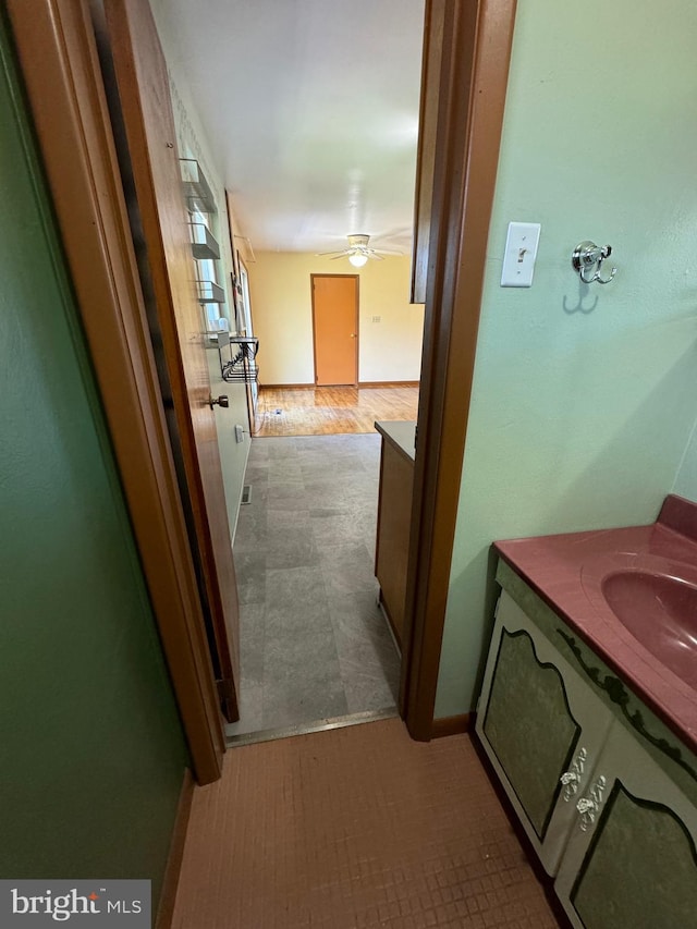 hall featuring a sink and baseboards