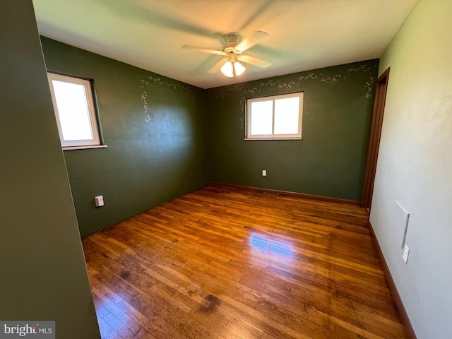 empty room with hardwood / wood-style floors and ceiling fan