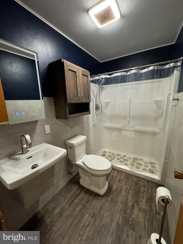 full bath featuring a sink, a shower stall, wood finished floors, and visible vents