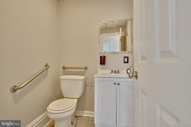 bathroom with toilet, tile patterned floors, baseboards, and vanity