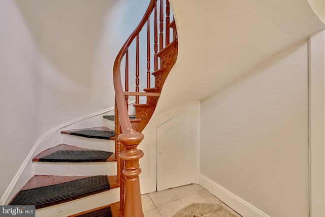stairs featuring baseboards and tile patterned flooring