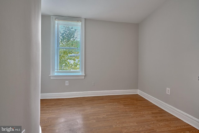unfurnished room with baseboards, plenty of natural light, and wood finished floors