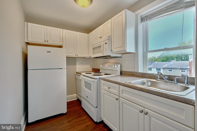 kitchen featuring a sink, a wealth of natural light, white appliances, and dark wood finished floors
