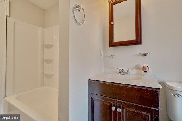 bathroom featuring vanity, walk in shower, and toilet