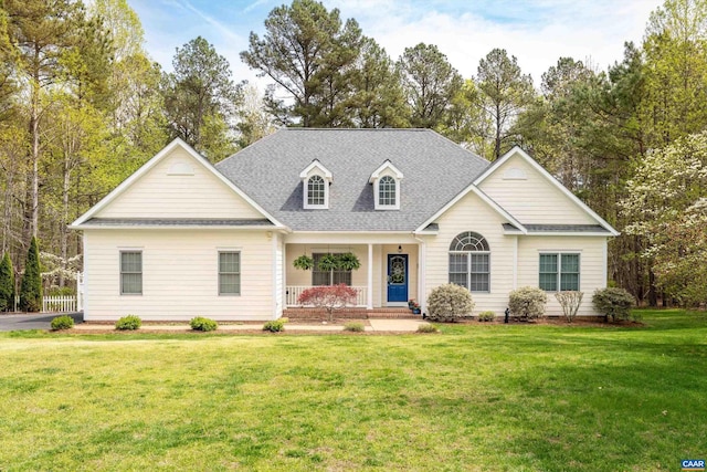 view of front of home featuring covered porch, a shingled roof, and a front lawn