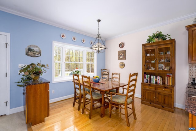 dining space with baseboards, a chandelier, ornamental molding, and light wood-style floors