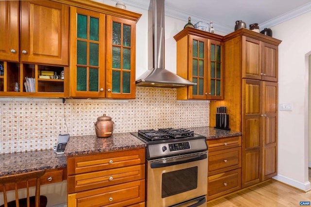 kitchen with gas stove, crown molding, backsplash, and wall chimney range hood