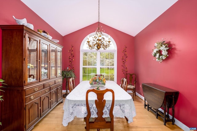 dining area with a notable chandelier, vaulted ceiling, baseboards, and light wood-type flooring