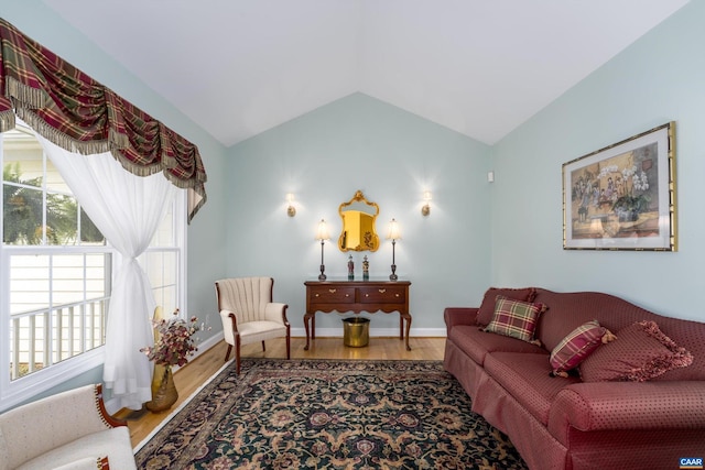 living room featuring baseboards, vaulted ceiling, and wood finished floors