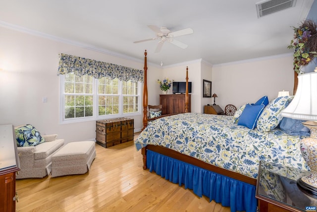 bedroom featuring light wood-style floors, ornamental molding, ceiling fan, and visible vents