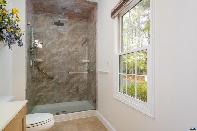bathroom featuring vanity, tile patterned flooring, toilet, baseboards, and a stall shower