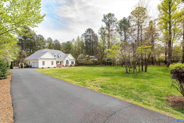 view of front of house featuring a garage, driveway, and a front lawn