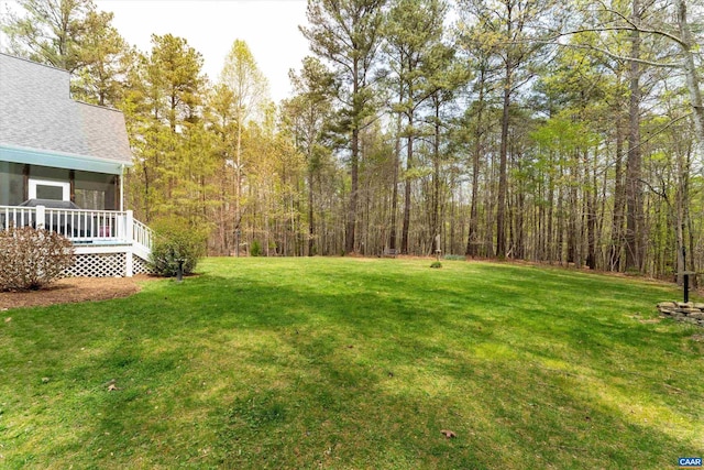 view of yard featuring a forest view and a sunroom