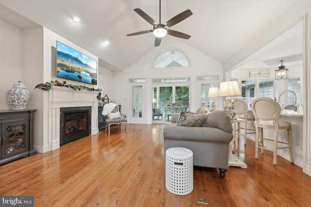 14595 Limestone Dr, Swan Point, MD 20645 - living area featuring ceiling fan, wood finished floors, plenty of natural light, a fireplace, and high vaulted ceiling