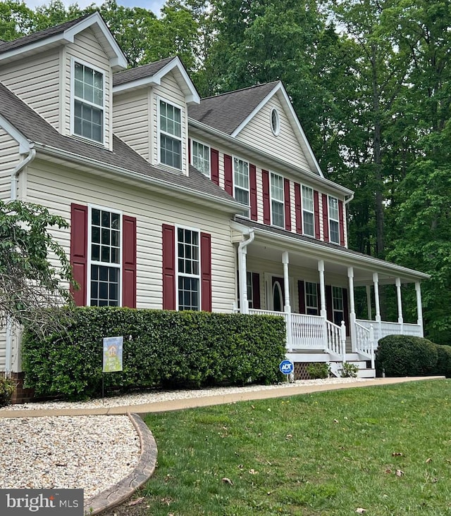 view of front facade featuring a front lawn, a porch, and roof with shingles