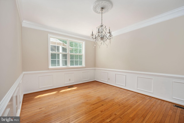 168 Sequester Dr, Stafford, VA 22556 - unfurnished room with a chandelier, crown molding, light wood-type flooring, wainscoting, and a decorative wall