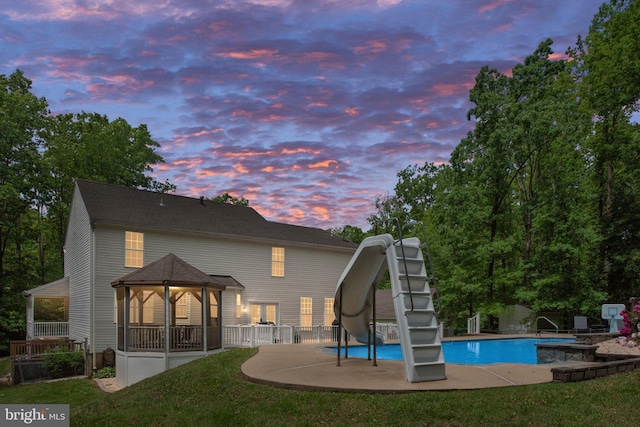 168 Sequester Dr, Stafford, VA 22556 - back of house at dusk with an outdoor pool, a patio, and fence