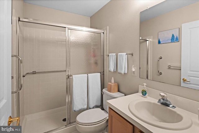 bathroom featuring vanity, a stall shower, and toilet