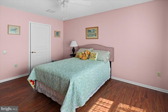 bedroom featuring baseboards, ceiling fan, wood finished floors, and visible vents