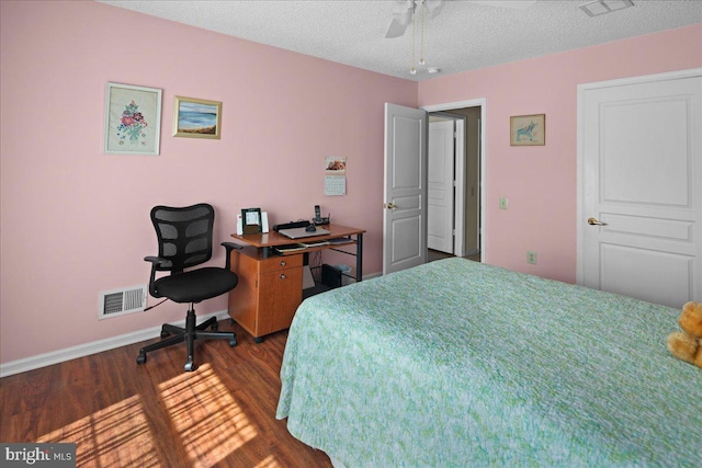 bedroom featuring a textured ceiling, baseboards, visible vents, and dark wood finished floors