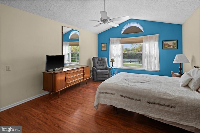 bedroom with lofted ceiling, wood finished floors, baseboards, a textured ceiling, and a ceiling fan