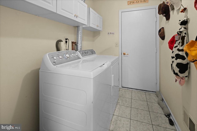 clothes washing area with cabinet space, independent washer and dryer, and light tile patterned flooring
