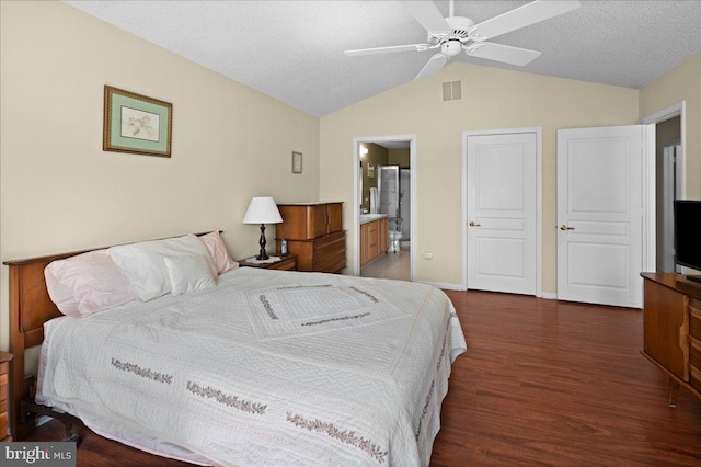 bedroom featuring visible vents, lofted ceiling, wood finished floors, ensuite bathroom, and ceiling fan