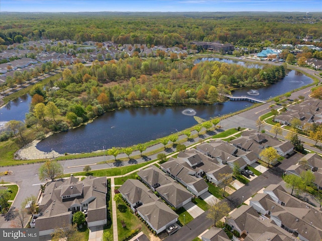 drone / aerial view with a water view, a residential view, and a forest view