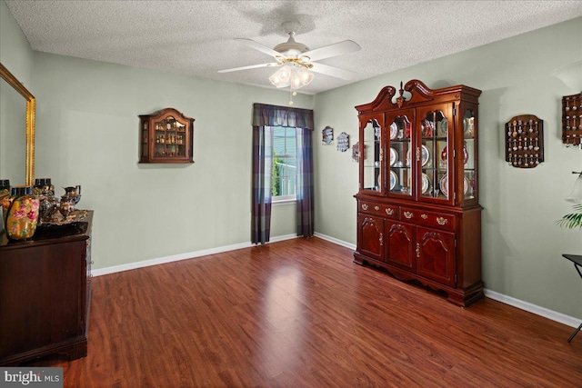 unfurnished room featuring baseboards, a textured ceiling, ceiling fan, and wood finished floors