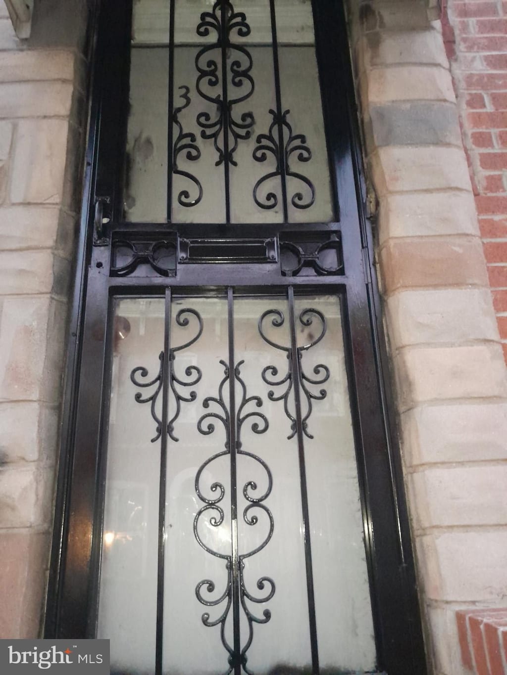 exterior details featuring a gate and brick siding