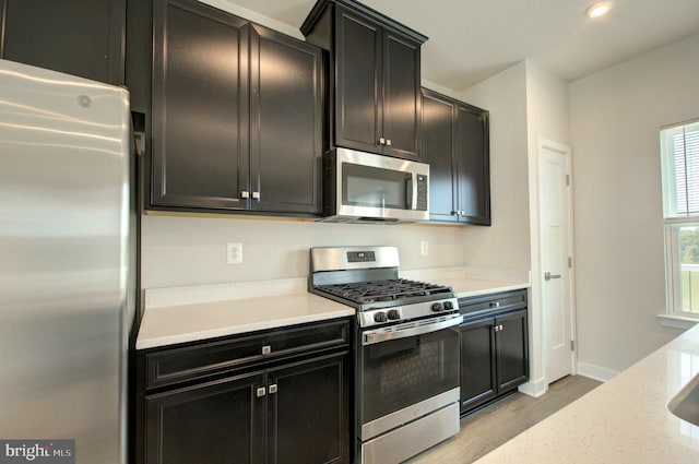 110 Fletcher Cir, Middletown, DE 19709 - kitchen with appliances with stainless steel finishes, light wood-style flooring, dark cabinets, baseboards, and recessed lighting