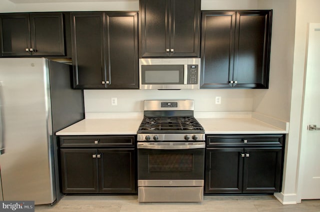 110 Fletcher Cir, Middletown, DE 19709 - kitchen featuring stainless steel appliances, light countertops, dark cabinetry, and light wood finished floors