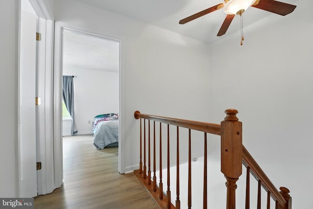 hallway featuring an upstairs landing and wood finished floors