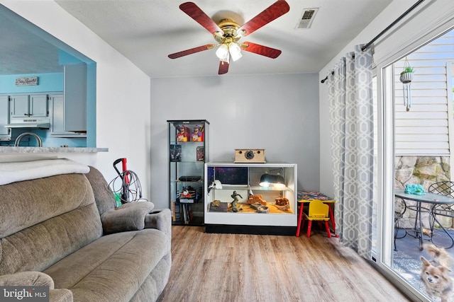 living room featuring visible vents, ceiling fan, and wood finished floors