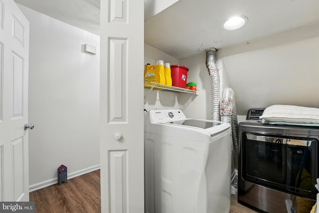 washroom with baseboards, laundry area, wood finished floors, and washer and dryer