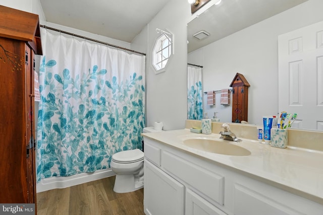 full bath featuring vanity, toilet, wood finished floors, and visible vents