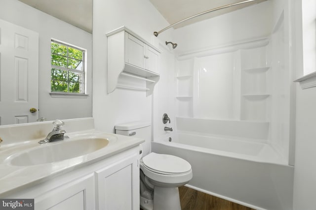 bathroom featuring shower / bathtub combination, toilet, wood finished floors, and vanity
