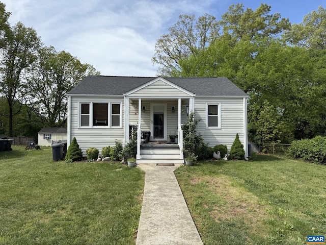 bungalow-style house with fence, a porch, a shingled roof, and a front yard
