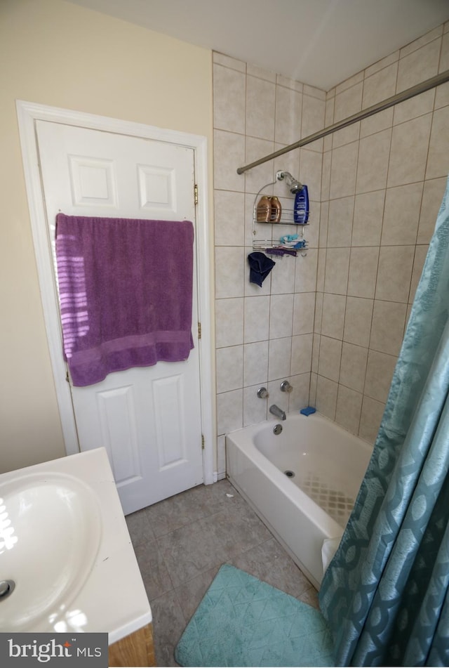 full bath featuring shower / bath combo with shower curtain, a sink, and tile patterned floors